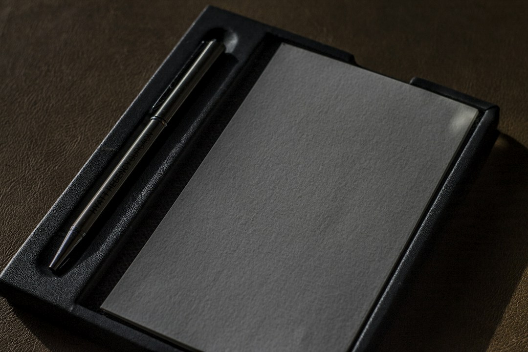 Dark notebook with pen laid diagonally across it