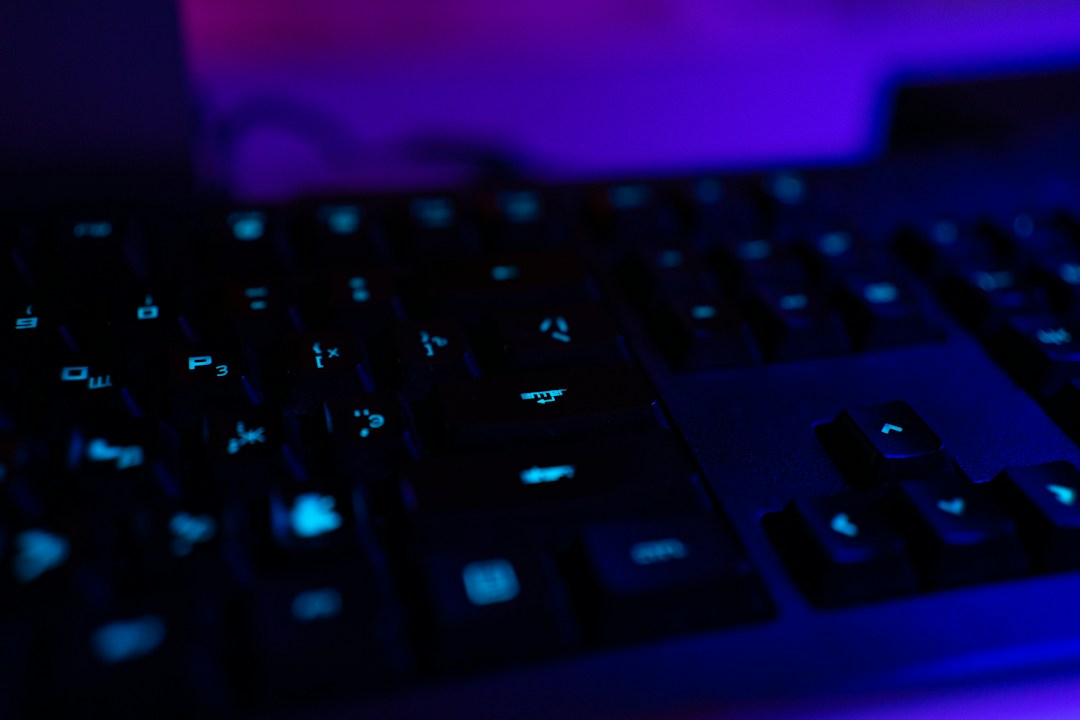 Computer keyboard illuminated by blue and violet light