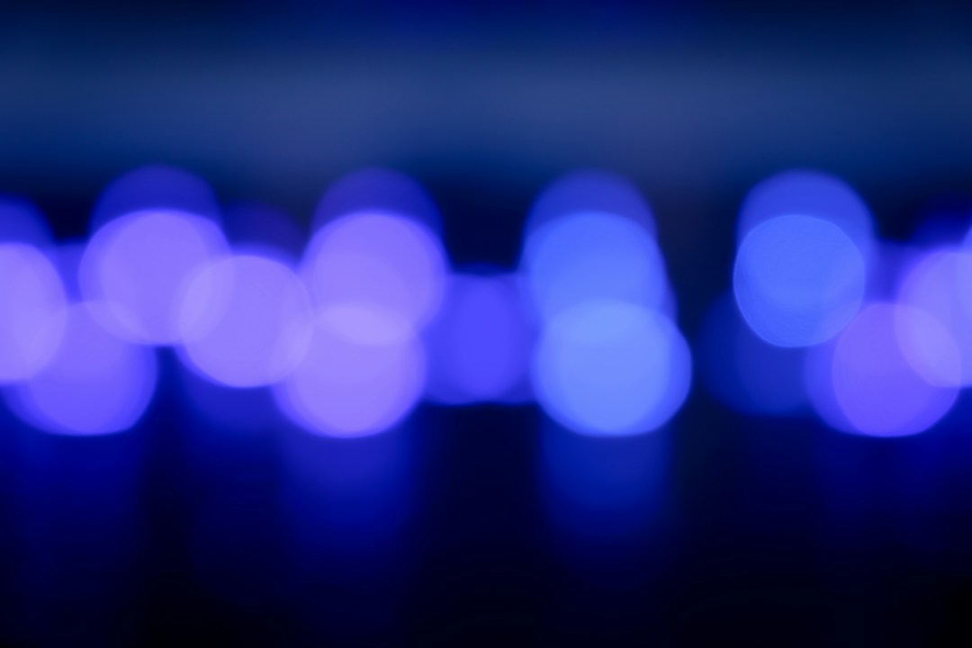 A row of blue lights out of focus on a dark background