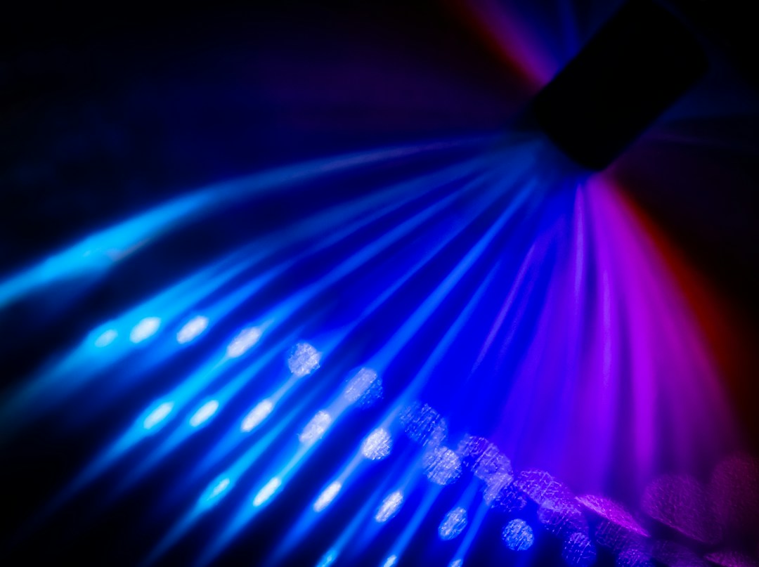 Blue and purple beams of light across a dark surface