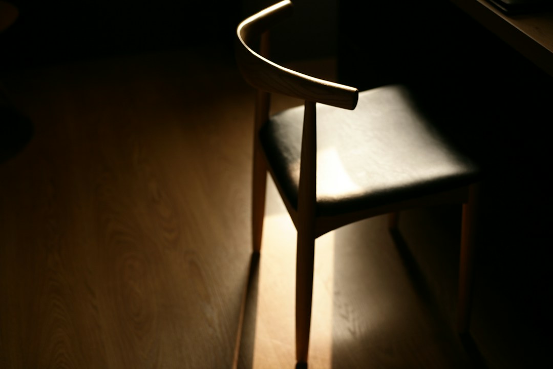 Wooden chair illuminated by a narrow beam of light